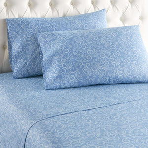 Blue bed sheets and pillowcases with a white swirling floral pattern