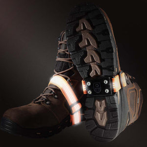 Brown work boots with illuminated orange LED safety bands attached to the heels and uppers