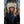 Woman wearing a beige shearling hat and brown leather gloves with a black coat