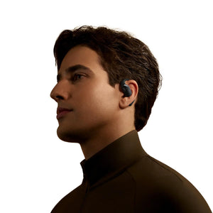 Profile view of a man wearing black open ear wireless earbuds