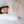 Person sleeping under a beige Outlast quilted blanket on a white pillow