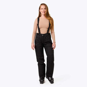 Woman wearing black ski pants with suspenders and black ski boots
