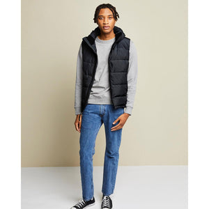 Man wearing a Kelvin black hooded puffer vest over a grey sweatshirt and blue jeans