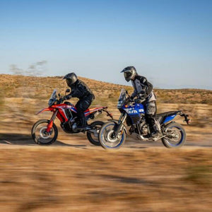 Two riders in Tourmaster gear riding dual sport motorcycles on a dirt trail