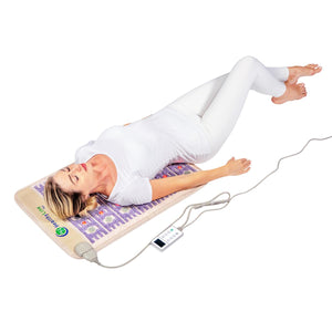 Person lying on a HealthyLine gemstone heating mat with a digital controller