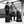 Two people standing with various Thule black luggage and bags in a transit area