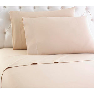 Shavel tan solid color bed sheet set with two pillows against a tufted headboard