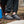Person wearing grey slip on outdoor slippers with black toggle closure
