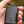 Black portable battery pack with four blue LED indicator lights held in a hand