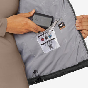 Hand placing a Venture Heat battery into the interior pocket of a heated jacket