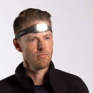 Man wearing a lit BioLite headlamp on his forehead