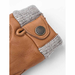 Tan leather Hestra glove cuff with grey ribbed knit trim and branded metal snap button