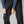 Person wearing black Fjallraven trekking trousers with side cargo pockets and stretch panels