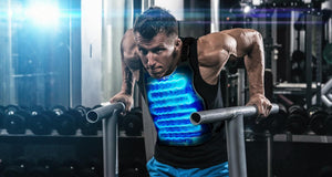 Man performing dips wearing an AlphaCool cooling vest with visible blue cooling channels