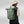 Person wearing a green Fjallraven rolltop backpack with bungee cord detail