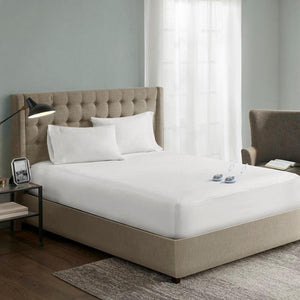 Serta white mattress pad on a bed with a tufted headboard