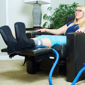 Person wearing Polar Products foot and ankle cold therapy wrap while resting in a recliner
