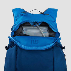 Ultimate Direction blue hydration backpack with open compartment showing water reservoir