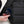 Hand placing a smartphone into the side pocket of a black Got Bag backpack