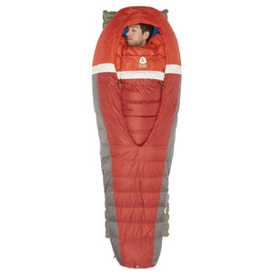 Person sleeping in a red and grey Sierra Designs mummy sleeping bag