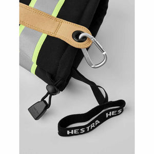 Hestra glove cuff with reflective tape, tan leather attachment point, carabiner, and branded wrist strap