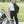 Man wearing California Heat black motorcycle pants standing next to a white motorcycle