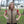 Woman wearing a tan HyperKewl quilted cooling vest over a red shirt