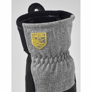 Hestra glove cuff with grey textured fabric and yellow Hestra logo patch
