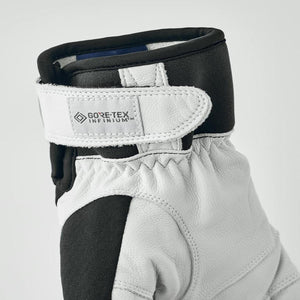 Close up of a white and black glove cuff with a Gore-Tex Infinium brand label on the velcro strap