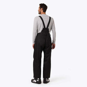 Man wearing Mobile Warming black bib overalls from the back