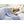 Person sleeping under a blue heated blanket with a digital controller on the bed