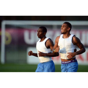 Two athletes running while wearing BodyCap cooling vests