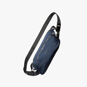 Bellroy navy blue sling bag with black adjustable strap and zipper closure