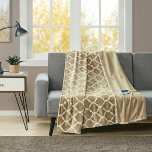 Tan and white patterned electric throw blanket draped over a grey sofa