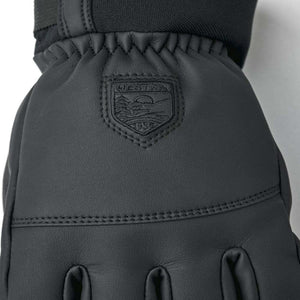 Black Hestra leather glove with embossed brand logo patch