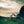 Snow Peak tent and tarp setup on a grassy cliff overlooking the ocean at sunset