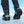 Person wearing black boots with Devisys ice cleats on snowy ground