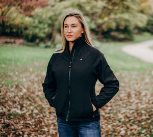 Woman wearing a black ActionHeat heated softshell jacket standing in a park