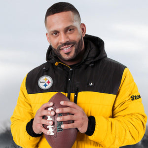 Man wearing a yellow and black ActionHeat Pittsburgh Steelers jacket holding a football
