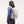 Person wearing a beige backpack with a side pocket holding a metal water bottle