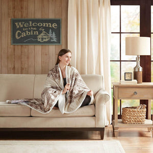 Woolrich patterned throw blanket draped over a person sitting on a beige sofa