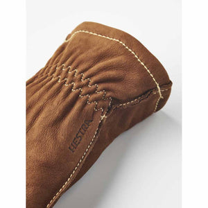 Close up of brown Hestra leather glove cuff with elasticated wrist and contrast stitching