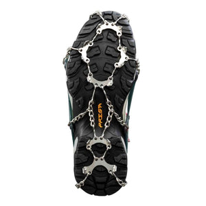 Metal traction spikes attached to the sole of a hiking boot