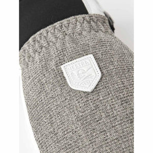 Close up of Hestra brand logo patch on grey textured glove fabric