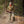 Woman in outdoor gear holding a shotgun in a forest