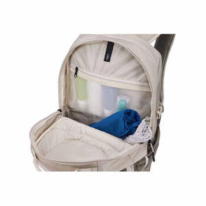 Open Thule backpack showing interior mesh pocket with toiletries and folded clothing