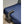Black bed cooling unit with flexible hose extending onto a blue bedspread