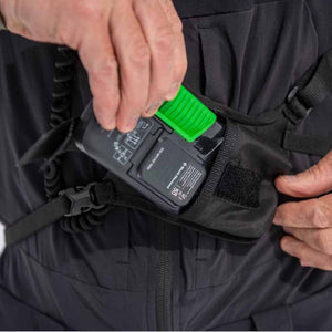 Person inserting a Black Diamond avalanche transceiver into a chest harness pocket