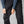 Close up of person wearing black Fjallraven trekking trousers with side cargo pockets and stretch panels