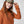 Person wearing a Fjallraven cap and an orange zip up fleece jacket